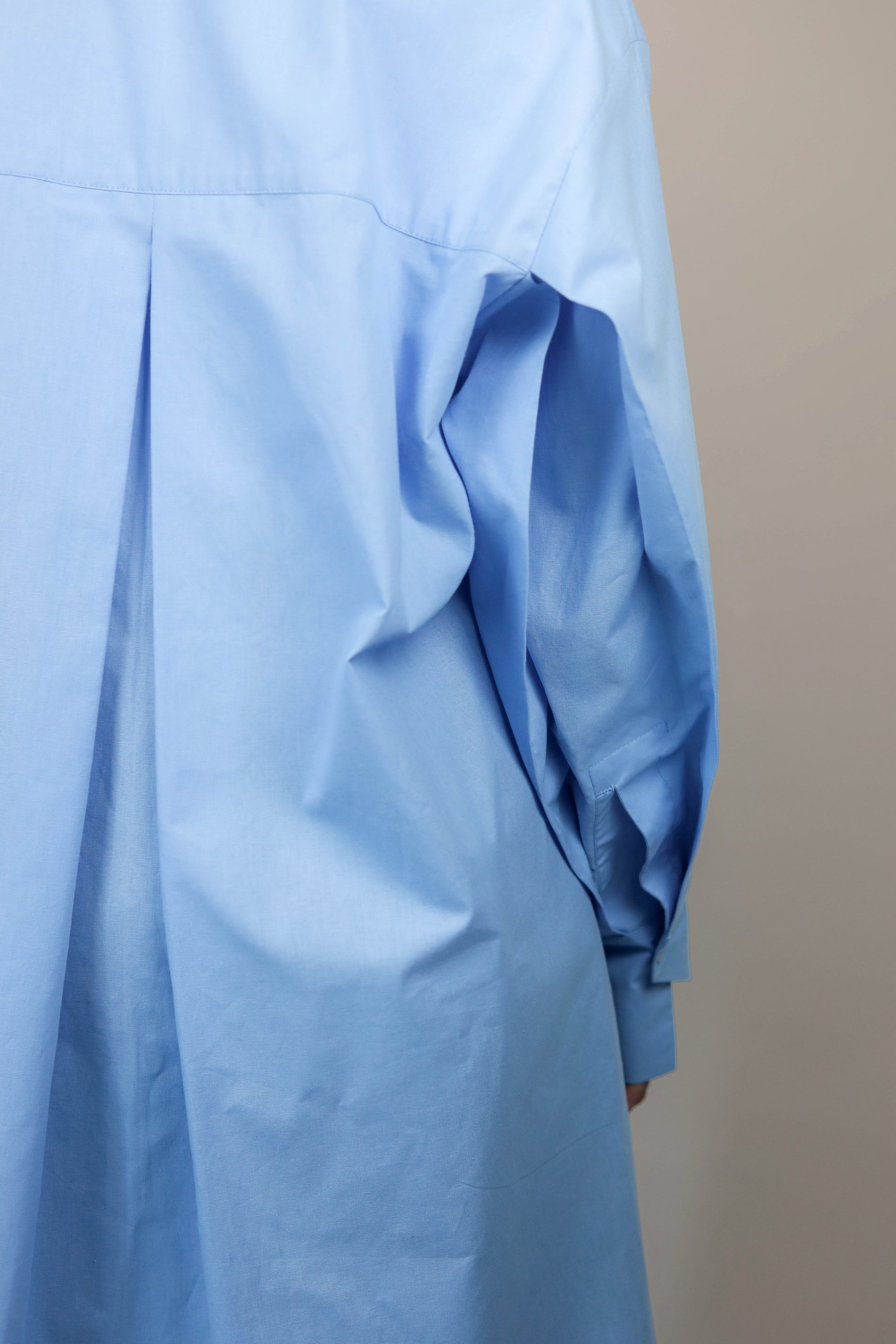 Detail asymetrickej manžety na dámskej oversize modrej košeli